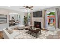 Cozy living room featuring a decorative fireplace, large windows, and open layout into the dining area at 111 E Church St, Stanley, NC 28164