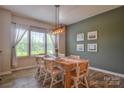 Bright dining room features a wood table, stylish lighting, and a large window with sheer curtains at 12531 Bryton Ridge Pkwy, Huntersville, NC 28078