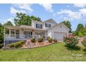 Beautiful home with a front porch, waterfall feature, and well-maintained landscaping at 130 Greenwich Dr, Statesville, NC 28677