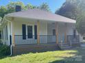 Charming front porch with a black railing, wooden posts, and a well-manicured lawn at 1327 Wiscassett St, Albemarle, NC 28001