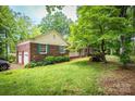 Traditional brick home with a detached garage, lush lawn, trimmed hedges, and mature trees at 1503 Brentwood Dr, Newton, NC 28658
