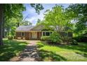 Traditional brick home boasts a welcoming brick walkway and lush landscaping under a beautiful blue sky at 1503 Brentwood Dr, Newton, NC 28658