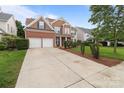 Spacious driveway leading to a two-story home with a well-kept lawn and manicured landscaping at 1572 Edenton Nw St, Concord, NC 28027