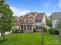 Beautiful home with a lush green lawn, a mix of brick and siding, and classic blue shutters at 1572 Edenton Nw St, Concord, NC 28027