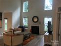 Spacious living room featuring a fireplace, high ceilings, large windows and neutral walls, bathed in natural light at 1572 Edenton Nw St, Concord, NC 28027