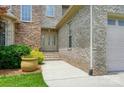 Close-up of the stone and brick front facade with a lush green lawn and landscaped garden at 1705 Townsend Ln, Rock Hill, SC 29730