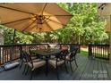 Enjoy outdoor dining on this deck featuring a table, chairs, an umbrella, and green views at 171 Secretariat Dr, Mooresville, NC 28117