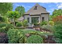 Exterior shot showing a serene stone patio area with seating and lush landscaping surrounding the home at 18718 Peninsula Cove Ln, Cornelius, NC 28031