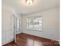 Inviting bonus room with wainscoting, large window, and hardwood floors at 2515 Walnut Forest Dr, Charlotte, NC 28216