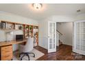 Inviting home office with built-in shelves, natural light, neutral colors, hardwood floors, and adjacent french doors at 2515 Walnut Forest Dr, Charlotte, NC 28216