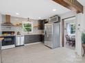 Bright kitchen featuring stainless steel appliances, dark wood cabinets, and tile backsplash at 2633 N Sharon Amity Rd, Charlotte, NC 28205