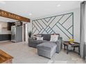 Open-concept living space with tile flooring, modern accent wall, and seamless flow to the kitchen at 2633 N Sharon Amity Rd, Charlotte, NC 28205