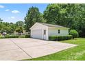 Detached garage with a large parking pad and green lawn at 2715 Kennetuck Ct, Charlotte, NC 28273