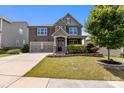 Stunning two-story house featuring a two-car garage, lush lawn, and stone veneer details at 2835 Berkhamstead Cir, Concord, NC 28027