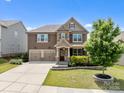 Charming two-story house with stone accents, a well-manicured lawn, and a spacious driveway at 2835 Berkhamstead Cir, Concord, NC 28027