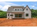 Back exterior of a modern farmhouse with a covered porch and large sliding glass doors at 3078 Mountain Creek Dr, Sherrills Ford, NC 28673