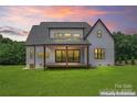 Back exterior of a modern farmhouse with a covered porch and large sliding glass doors at 3078 Mountain Creek Dr, Sherrills Ford, NC 28673