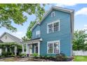 Charming blue two-story home with a welcoming front porch and beautifully landscaped front yard at 314 Center Dr, Davidson, NC 28036