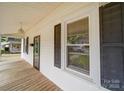 A view along the long, covered front porch that has a wooden floor and the house number on the door at 318 Chestnut Ave, Kannapolis, NC 28081