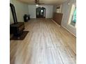 Spacious living room featuring newer floors, a ceiling fan, and wood burning stove at 4112 Hill Haven Dr, Vale, NC 28168
