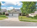 Charming two-story home with a three-car garage, lush lawn, and mature trees at 4352 Haddington Dr, Fort Mill, SC 29707
