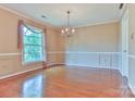 Bright dining room with hardwood floors, chandelier, and a large window offering natural light at 466 Shiloh Church Rd, Hickory, NC 28601