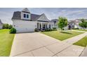 Exterior home view showcasing a large driveway, manicured lawn, and inviting curb appeal at 4689 Kingswood Dr, Indian Land, SC 29707