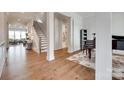 Open foyer area with hardwood floors, stairs leading up, and a view into a living space at 4689 Kingswood Dr, Indian Land, SC 29707