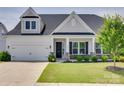 Traditional home featuring stone accents, a covered porch, and lush green lawn at 4689 Kingswood Dr, Indian Land, SC 29707