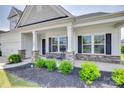 Inviting covered front porch with stone pillar bases, space for seating, and tidy landscaping at 4689 Kingswood Dr, Indian Land, SC 29707