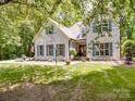 Stunning white brick home featuring lush greenery, blue shutters, and a well-manicured lawn at 4715 Lenden Hall Ct, Gastonia, NC 28056