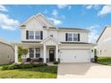 Charming two-story home featuring a well-manicured lawn, a covered porch, and a two car attached garage at 5121 Ennisworth Ln, Charlotte, NC 28214