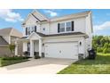 Charming two-story home featuring a well-manicured lawn, a covered porch, and a two car attached garage at 5121 Ennisworth Ln, Charlotte, NC 28214
