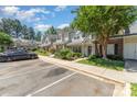 A well-maintained townhome featuring assigned parking in front, manicured landscaping, and traditional siding at 7504 Petrea Ln, Charlotte, NC 28227