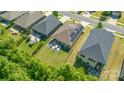 This aerial view shows a home with a spacious backyard, patio, and solar panels, surrounded by mature trees at 7530 Porrera St, Charlotte, NC 28214