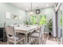 Dining room with a white table, stylish lighting fixture, and a sliding glass door for natural light at 7530 Porrera St, Charlotte, NC 28214