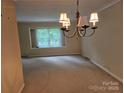 Traditional dining room features a chandelier and sunlit window creating a warm and inviting atmosphere at 7608 Surreywood Pl, Charlotte, NC 28270