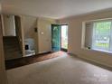 Inviting living room features a bright window, neutral walls, and hardwood floors with staircase nearby at 7608 Surreywood Pl, Charlotte, NC 28270