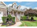 Inviting front porch with brick and column detailing, offering a warm entrance to the home at 8717 Swift Rd, Oakboro, NC 28129