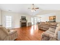 Spacious living room featuring hardwood floors, a fireplace, and a ceiling fan at 8717 Swift Rd, Oakboro, NC 28129