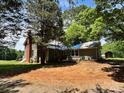 Rear exterior view shows the house with mature trees surrounding it, creating a private backyard at 9401 Gold Hill Rd, Mount Pleasant, NC 28124