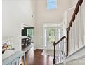 Bright foyer features hardwood floors, soaring ceilings, staircase, and a glimpse into the formal dining room at 9507 Reid Hall Ln, Matthews, NC 28105