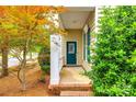 Inviting front porch with brick steps, columns, and a teal front door, surrounded by lush landscaping at 10407 Alvarado Way, Charlotte, NC 28277