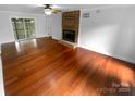 Spacious living room boasting hardwood floors and a brick fireplace ready for your personal touches at 10518 Fairway Ridge Rd, Charlotte, NC 28277