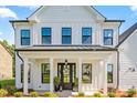 Inviting front porch with black double doors, a modern metal roof, and white columns at 1149 Rosecliff Dr, Waxhaw, NC 28173