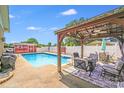 Outdoor seating under a covered pergola next to a refreshing backyard pool at 1204 N 12Th St, Bessemer City, NC 28016
