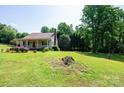 Well-maintained single-story home with green lawn surrounded by mature trees at 1276 Beechwood Dr, Newton, NC 28658