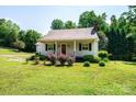 Quaint single-story home featuring a beautifully landscaped front yard with vibrant flower bushes at 1276 Beechwood Dr, Newton, NC 28658