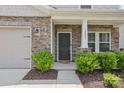 Charming front entrance featuring a dark front door flanked by green shrubs and brick accents at 15023 Longmoore Dr, Charlotte, NC 28278