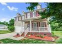 Two-story home featuring a front porch, manicured lawn, and attached garage at 1503 Stoney Ct, York, SC 29745
